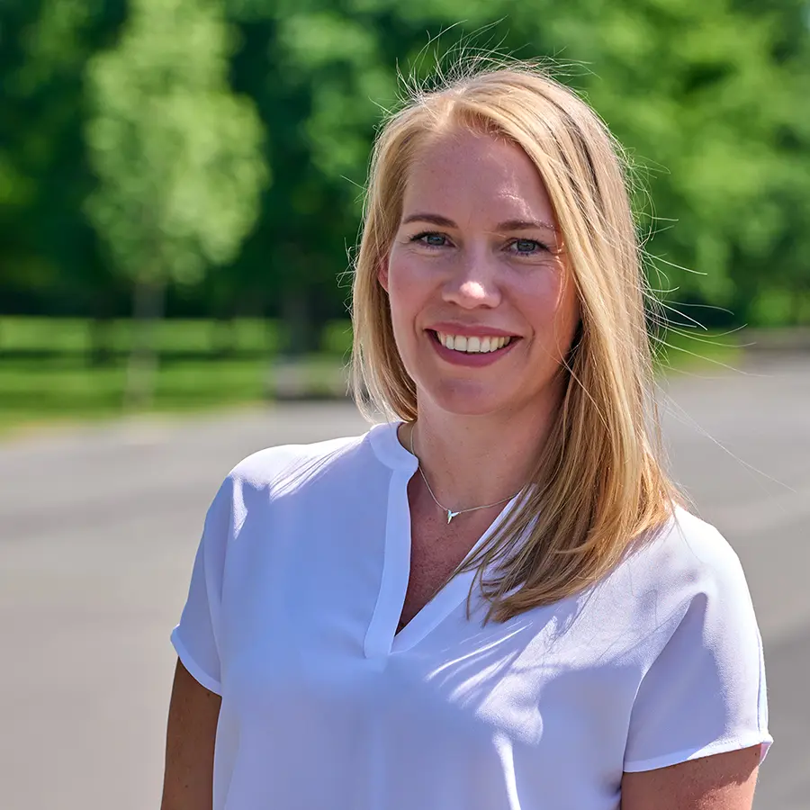 Marlen Vogel, lächelnd im Sonnenschein – zertifizierter Business Coach.